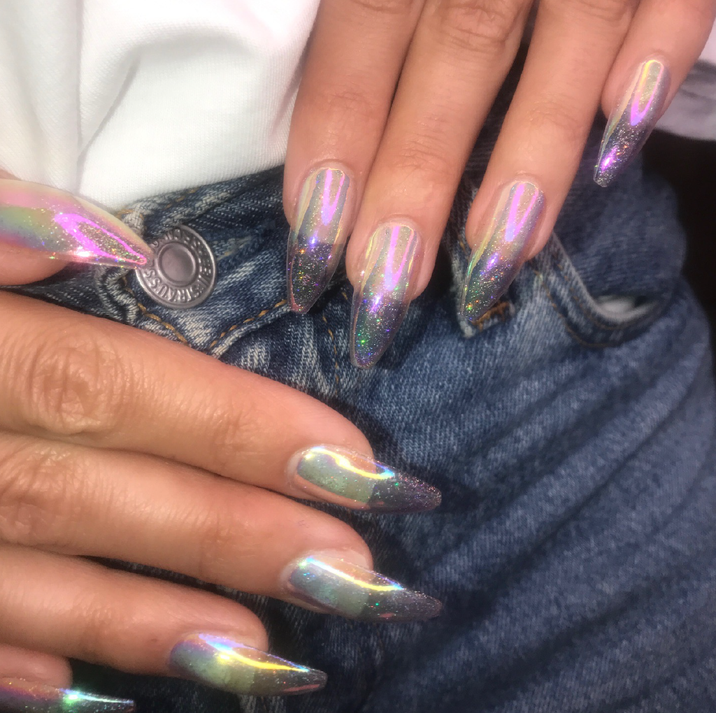 Model wears tapered ballerina long stick on nails in holographic and iridescent glitter