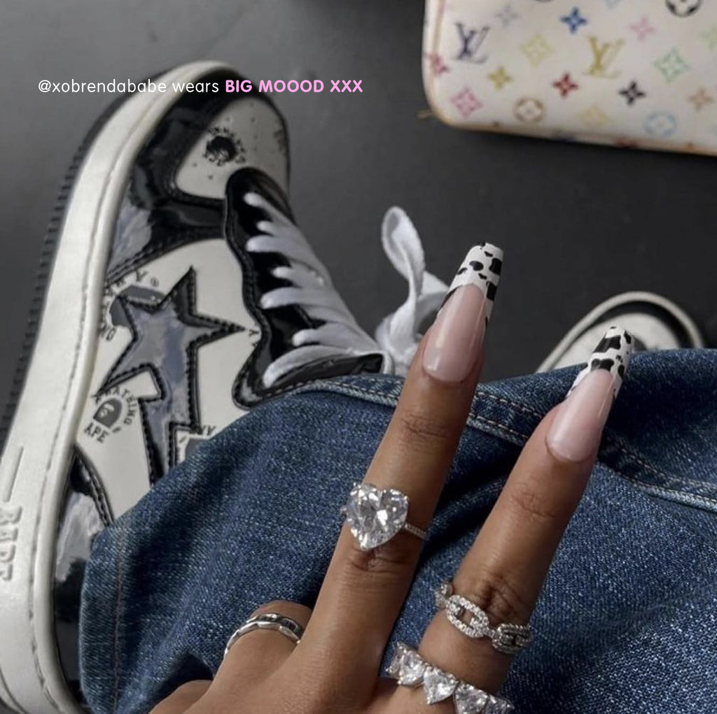 Influencer wearing ultra long coffin press on nails in cow print french