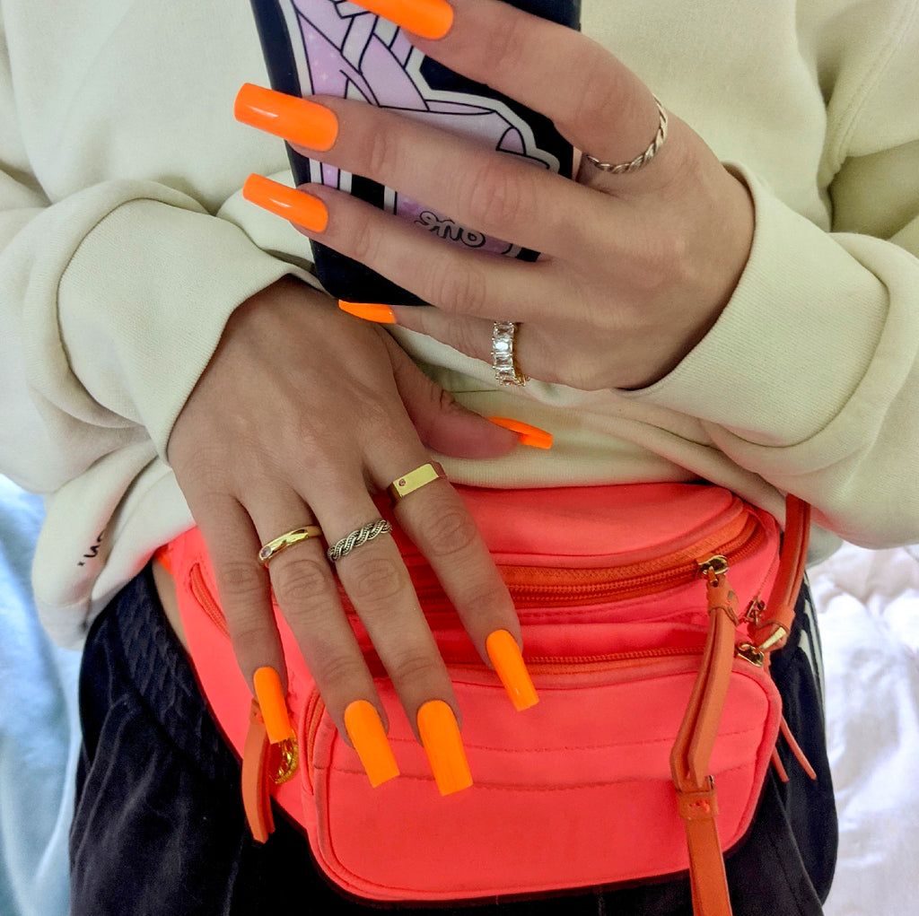 Influencer wears long square press on nails in neon orange