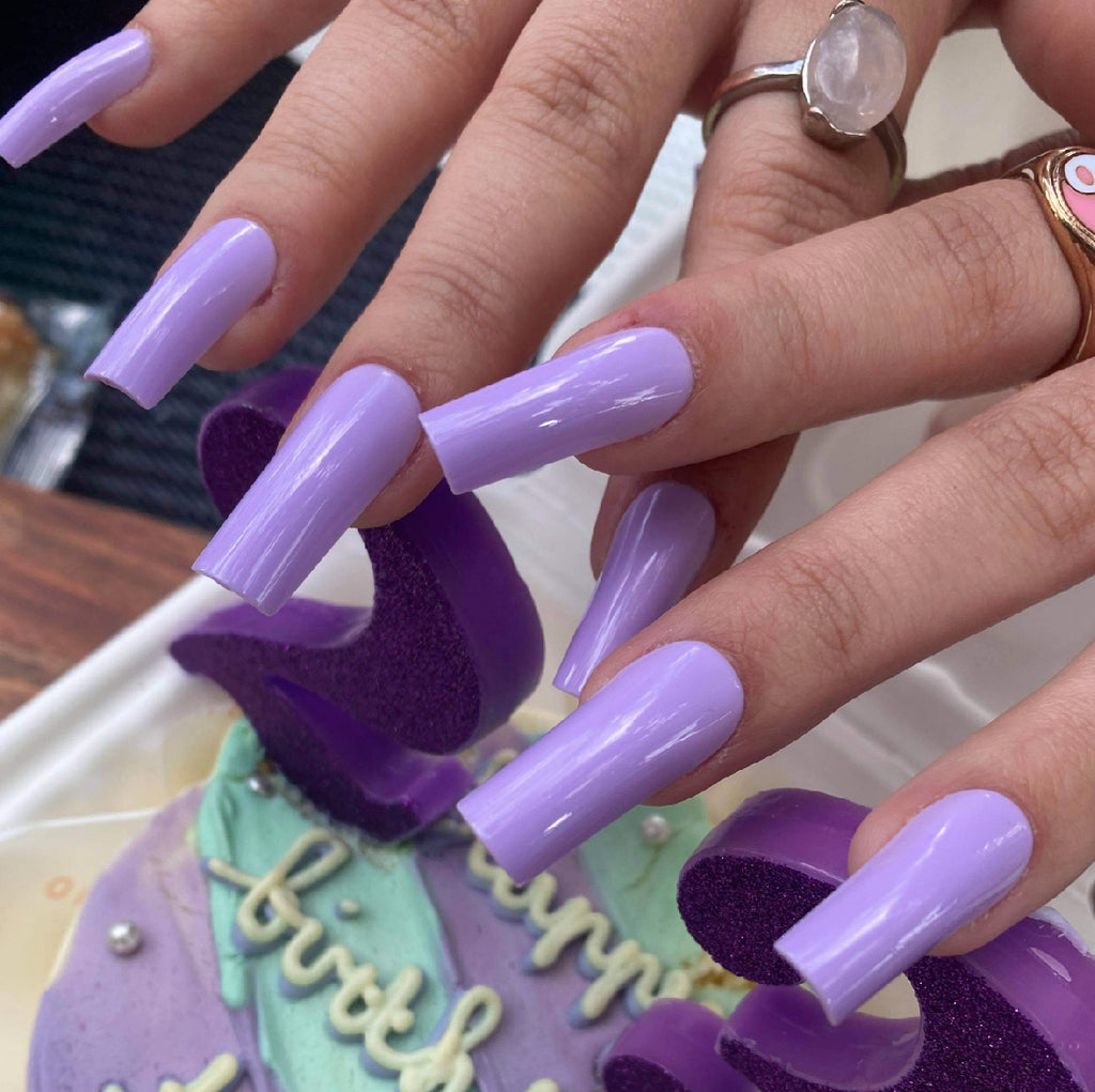 Influencer wears long square press on nails in bright purple