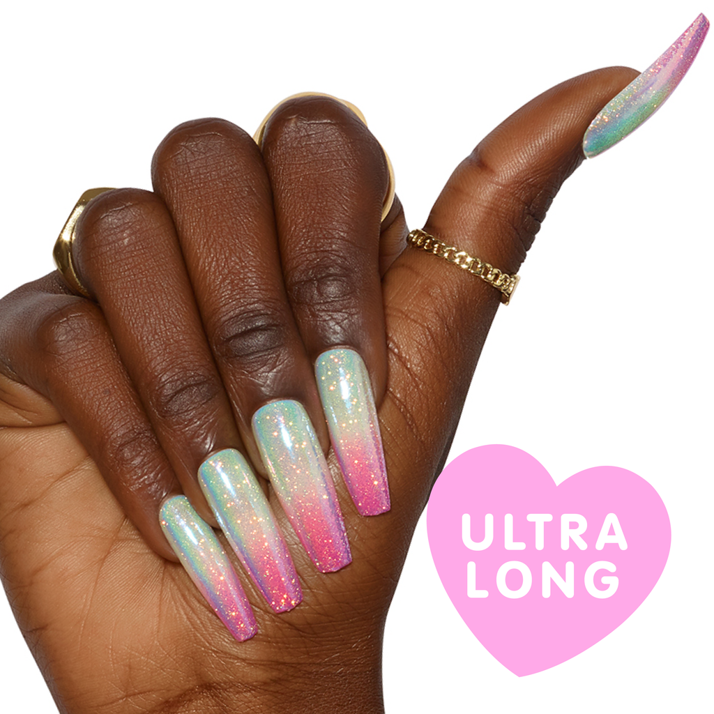 Close up of hand wearing pastel ombre press on nails with glitter top coat in ultra long coffin
