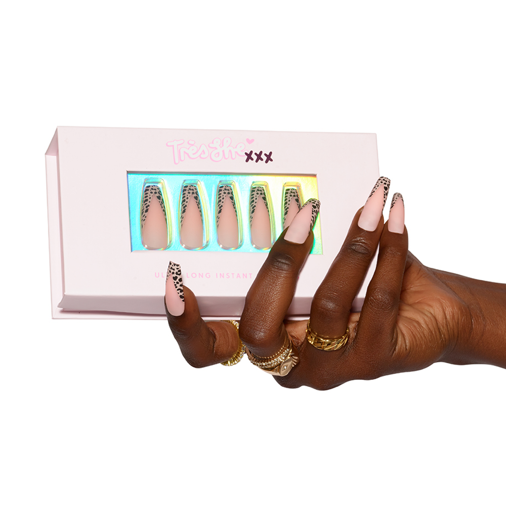 Hand holding Tres She XXX Ulra Long packaging of Wild Tingz press on nails